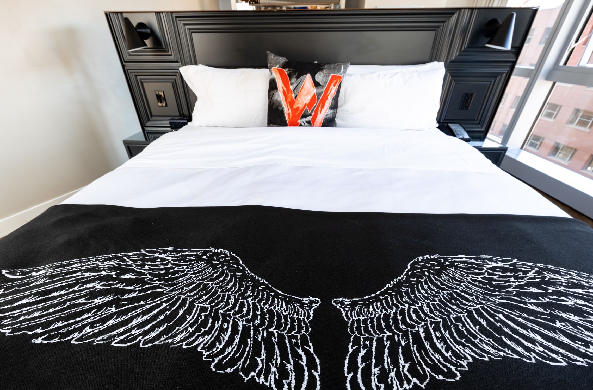Explore a modern bedroom in Boston with stylish decor and unique wing design bedspread.
