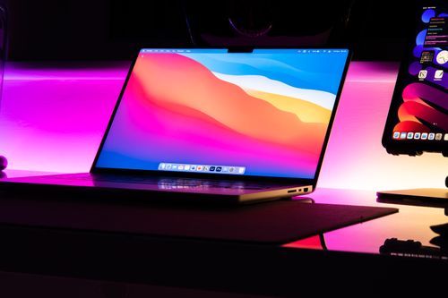 Free Modern laptop on a desk with a glowing neon background, perfect for tech lifestyle imagery. Stock Photo