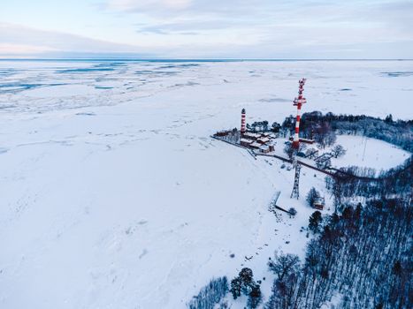 A scenic aerial view of Shepelevo Lighthouse surrounded by snow and ice in Leningrad Oblast, Russia.