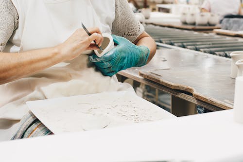 Person Wearing Green Glove While Carving 