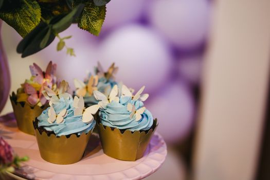 Beautifully decorated cupcakes with butterfly toppers and blue frosting, perfect for celebrations.