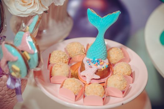 A whimsical mermaid themed dessert plate featuring candies and decorations perfect for parties.