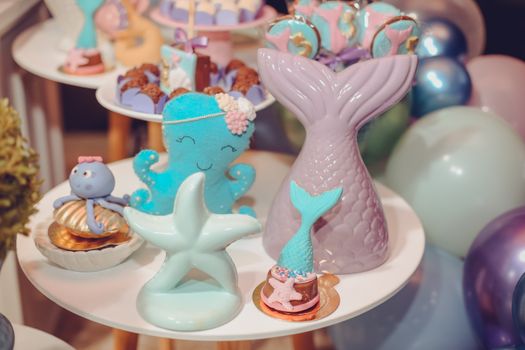 Underwater-themed party table with mermaid and sea creature decorations.
