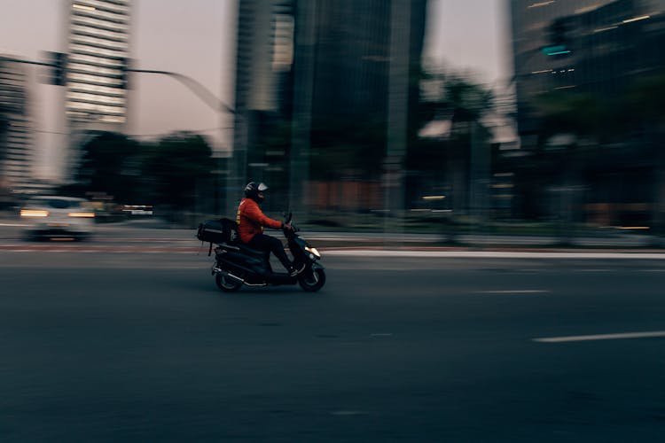 Riding Scooter On Street In City