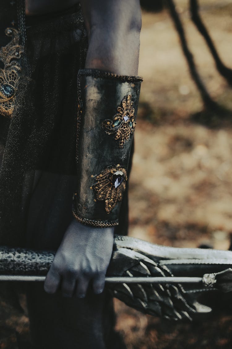 Man Hand In Metal Armor Holding Bow And Arrow