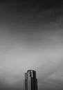 一座高楼的黑白图像醒目地映在戏剧性的多云天空下