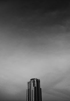 一座高楼的黑白图像醒目地映在戏剧性的多云天空下