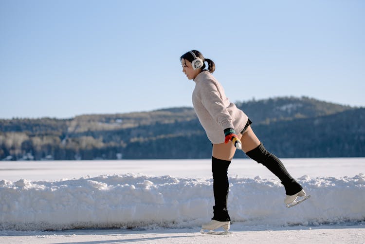 Woman Ice Skating On Frozen Lake