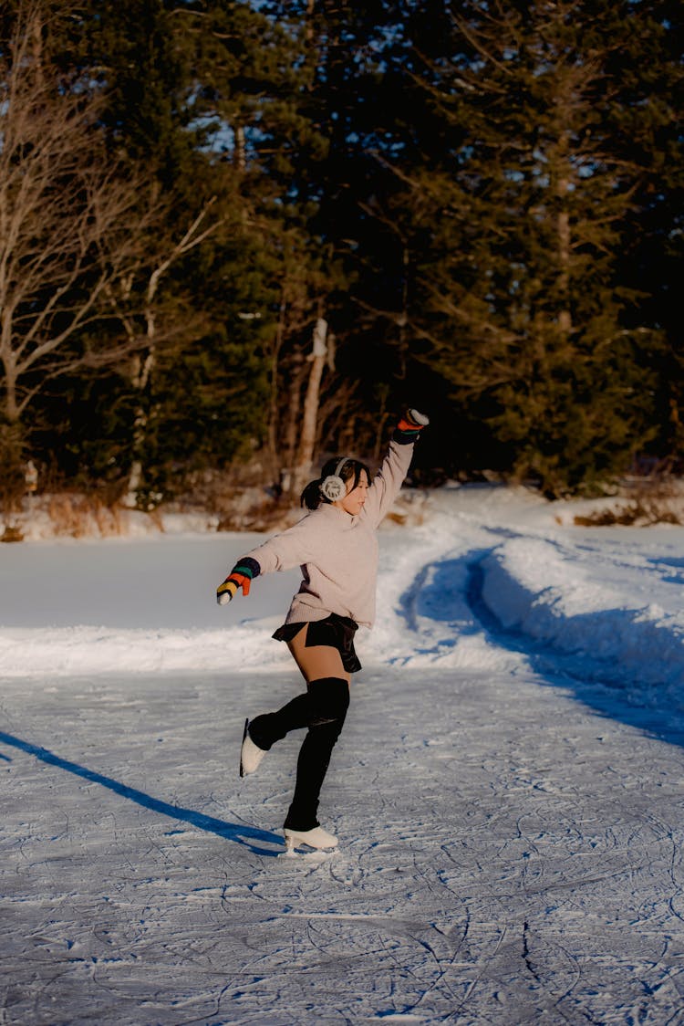 Woman Ice Skating On Frozen Lake