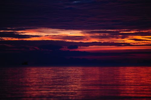 Free Breathtaking sunset reflecting on calm ocean waters, showcasing vibrant sky colors. Stock Photo
