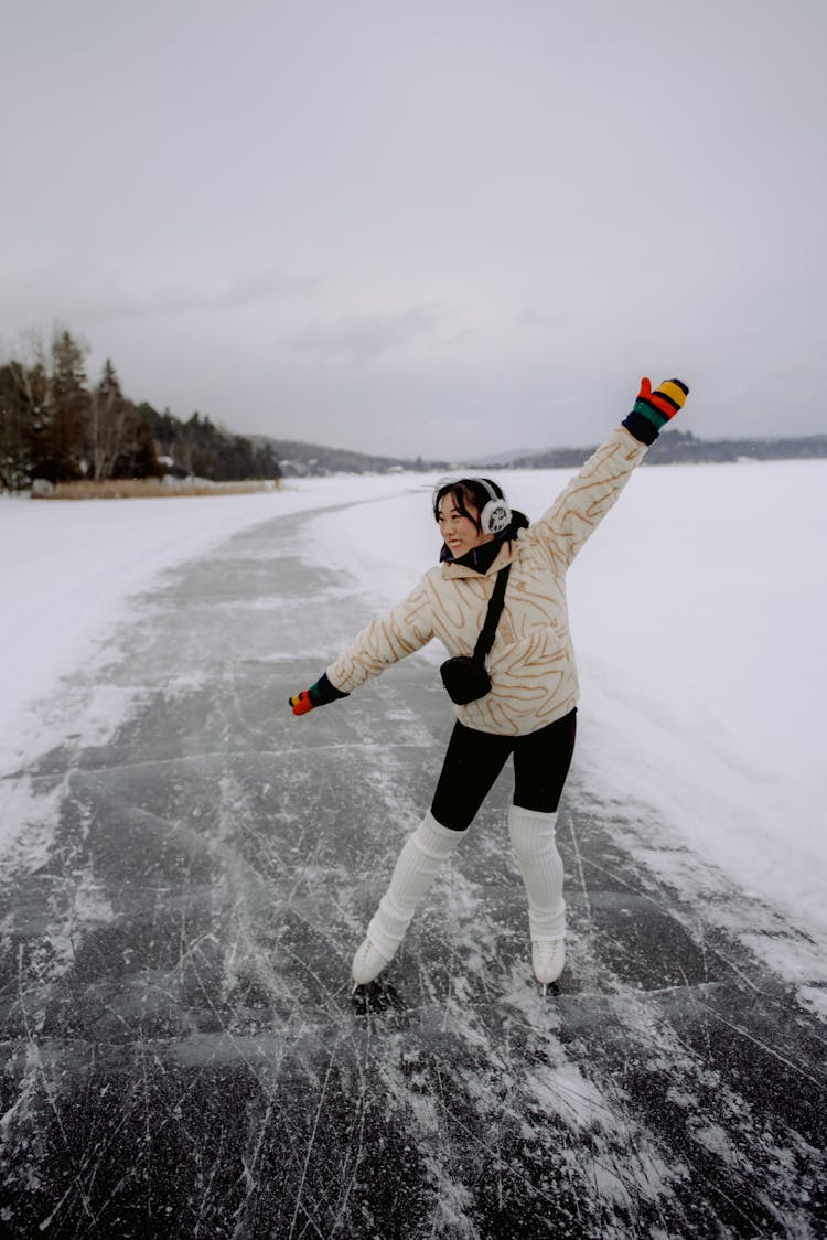 Woman Ice Skating On Frozen Lake