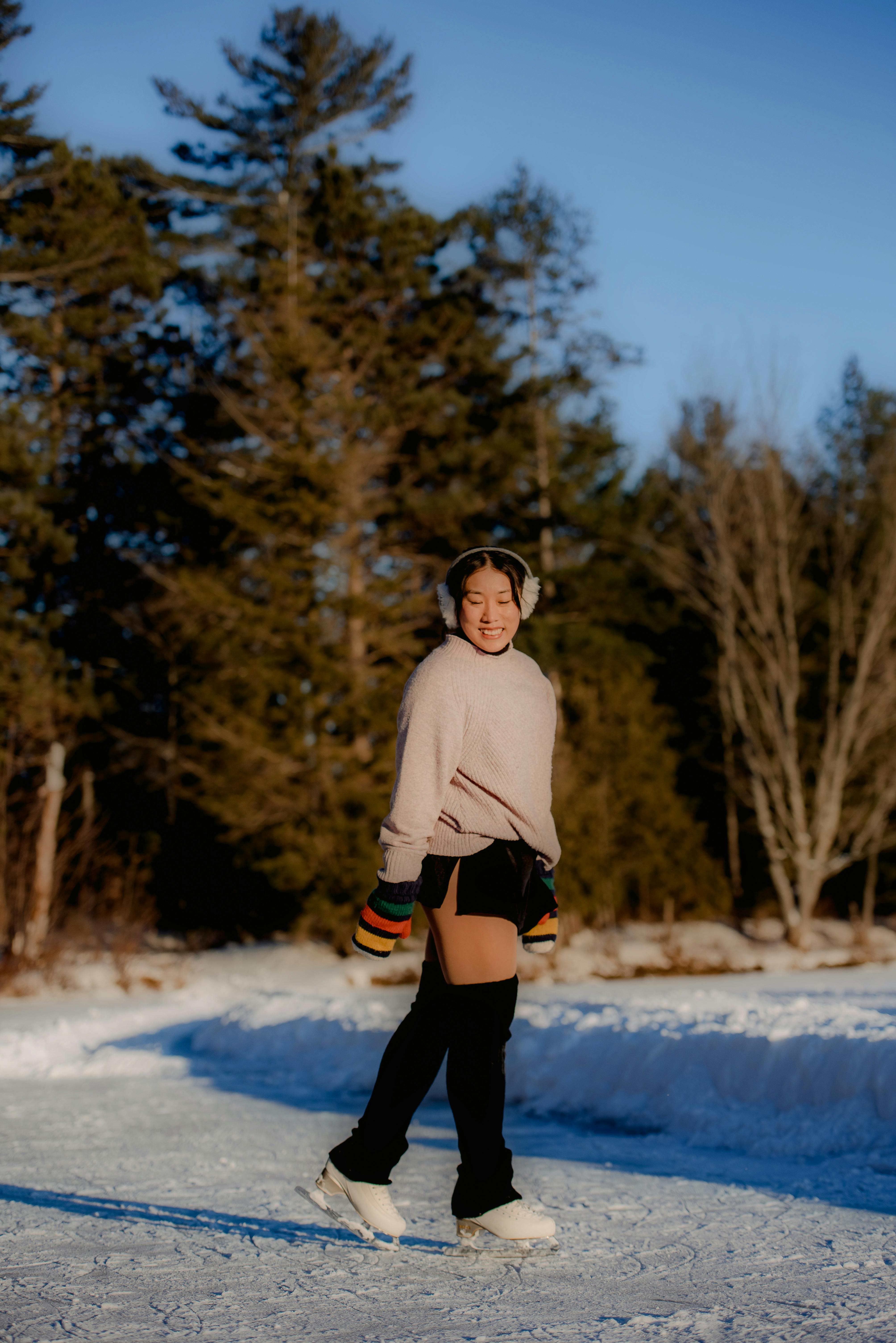 Prescription Goggle Inserts - Woman ice skating on a snowy path surrounded by trees, enjoying a sunny winter day.