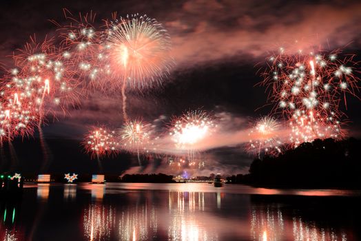 Dazzling fireworks light up the night sky over Lake Buena Vista, FL, creating a stunning reflection on the water.