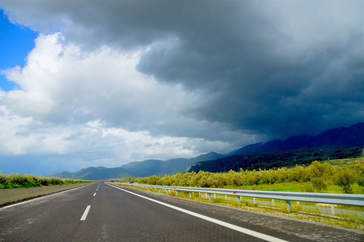 Autostrada lunga sub nori dramatici, in Grecia