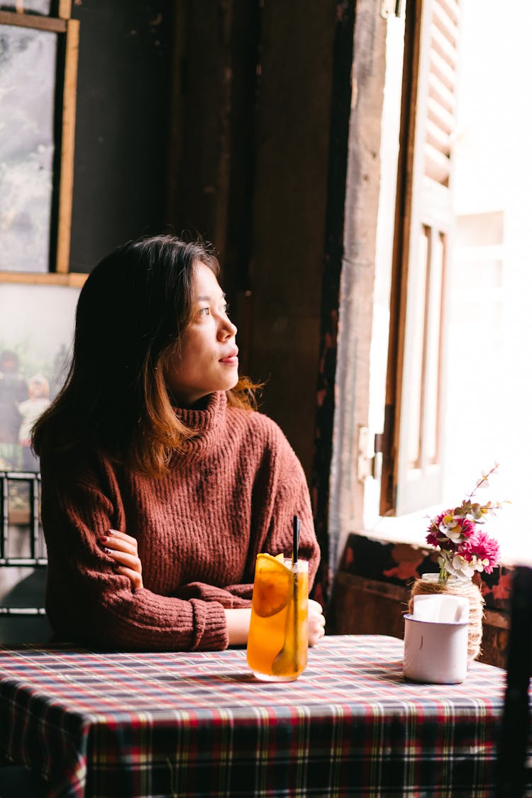 Woman Sitting At Restaurant Table