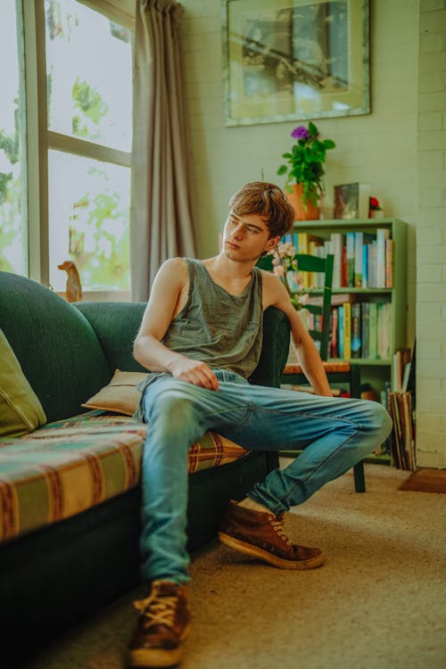 Free A Young Man Sitting on the Sofa Stock Photo