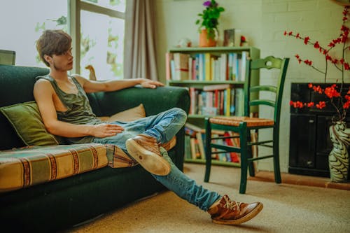 Free A Young Man Sitting Comfortably on the Sofa Stock Photo