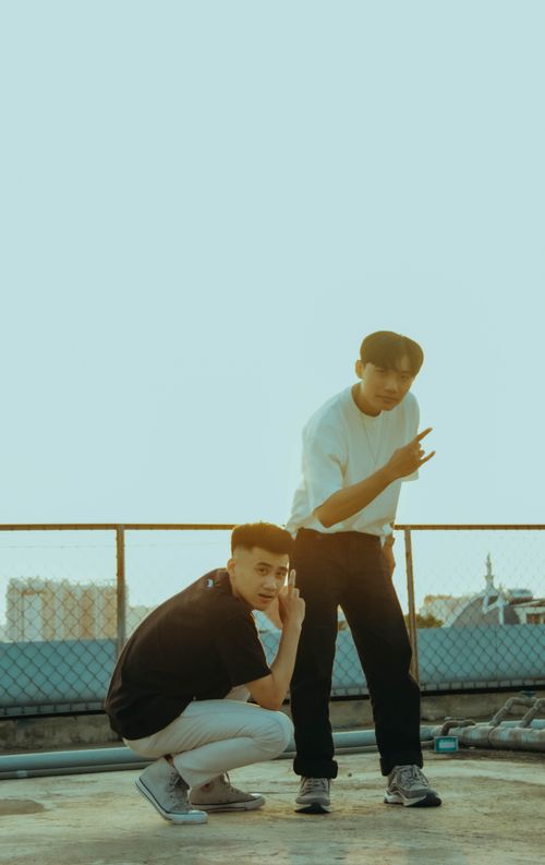 Free Two young men posing on a rooftop during sunset, showcasing urban youth culture. Stock Photo