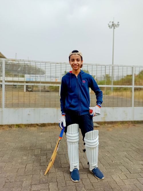 Free Young cricket player wearing gear and smiling outdoors in Gahunje, India, showcasing sports passion. Stock Photo