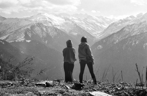 Free Two individuals view a stunning mountain vista, embodying exploration and wanderlust. Stock Photo