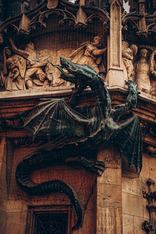 Free Black Dragon Statue on Brown Wooden Wall Stock Photo