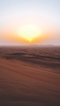 Breathtaking sunset over the tranquil sand dunes of Dubai desert, showcasing natural beauty and serenity.