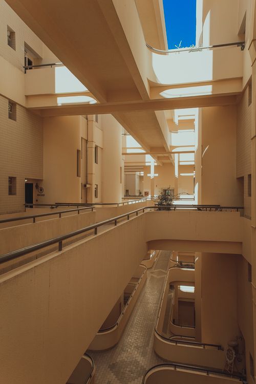 Free Modern interior view of an apartment building in Abu Dhabi showcasing concrete corridors and railings. Stock Photo