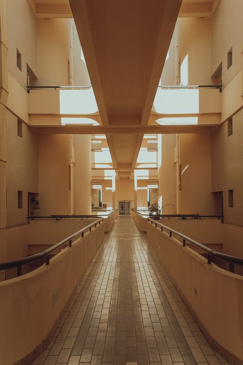 Free Spacious modern corridor with glass walls and tiled floor, showcasing unique architecture in Abu Dhabi. Stock Photo
