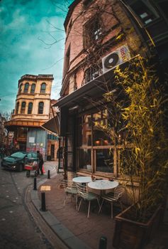 Vibrant urban scene with a cozy sidewalk cafe on a charming street corner surrounded by historic architecture.