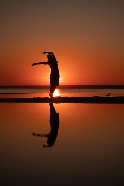Silhouette of a dancer leaping against a burning sunset, by Nikita Korchagin on Pexels