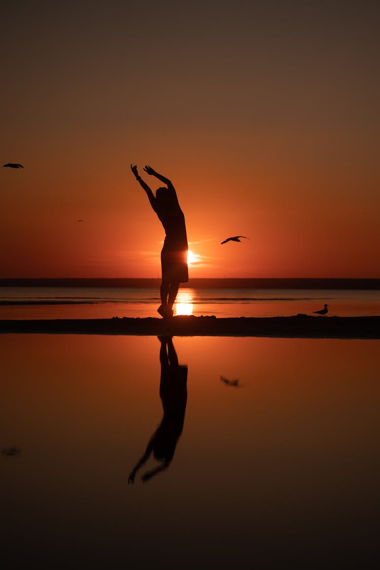 Silhouette Of A Woman Dancing During Sunset