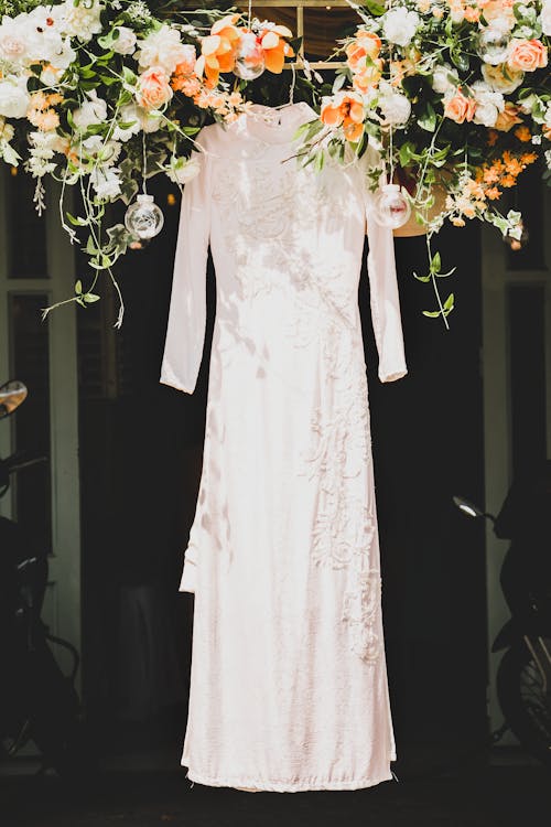 A White Dress Hanging with Flowers on the Side