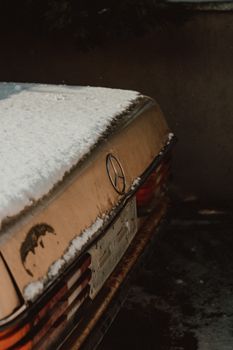 Close-up of a rusty Mercedes Benz parked in snow, showcasing vintage charm with winter elements in Turkey.