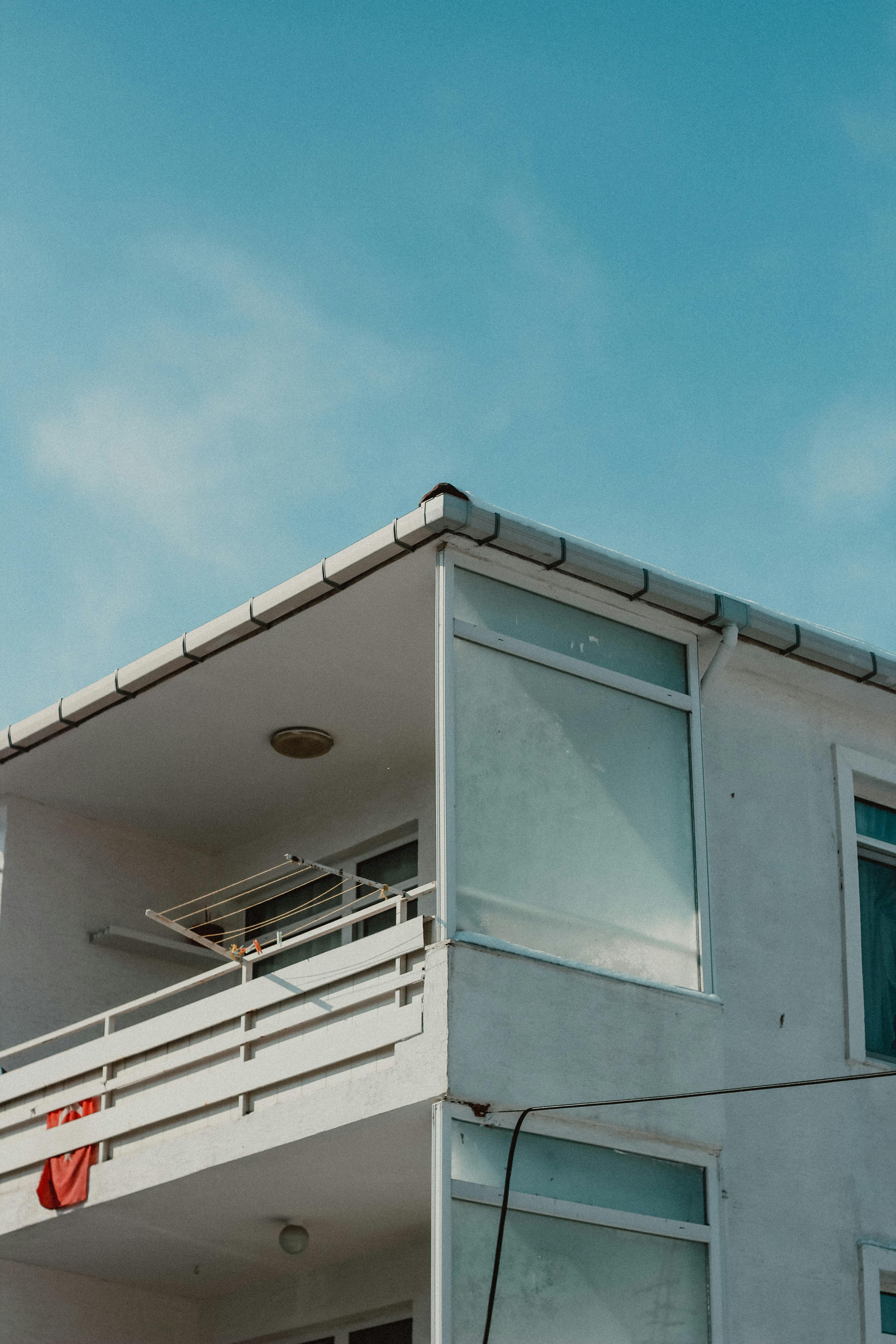 Close-up of a modern white building balcony against a clear blue sky, showcasing minimalistic architecture in Turkey.