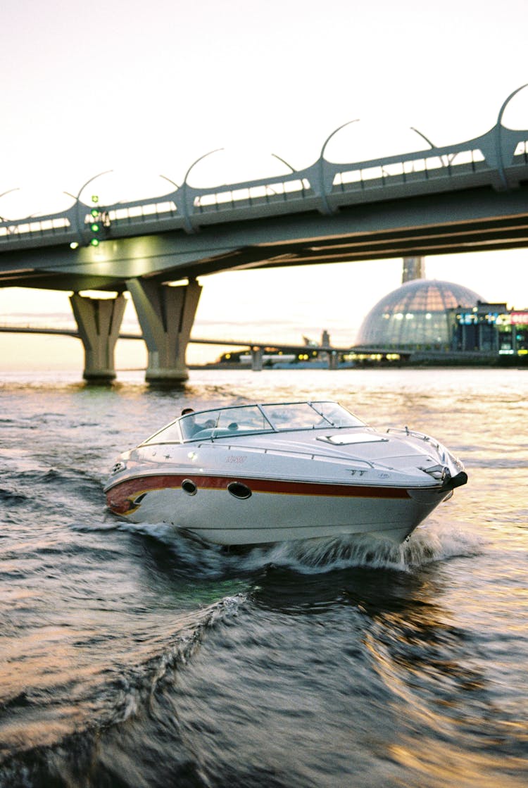 Boat Sailing At Sea With Bridge In Background