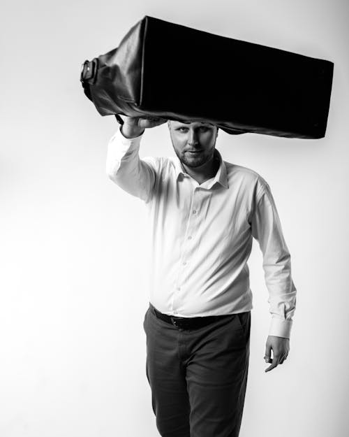 A Man in White Long Sleeves Holding a Black Bag