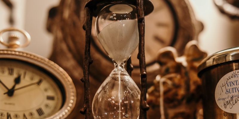 Antique clocks and an hourglass in warm light