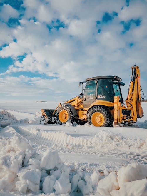 Yellow and Black Bulldozer on Snow Covered Ground