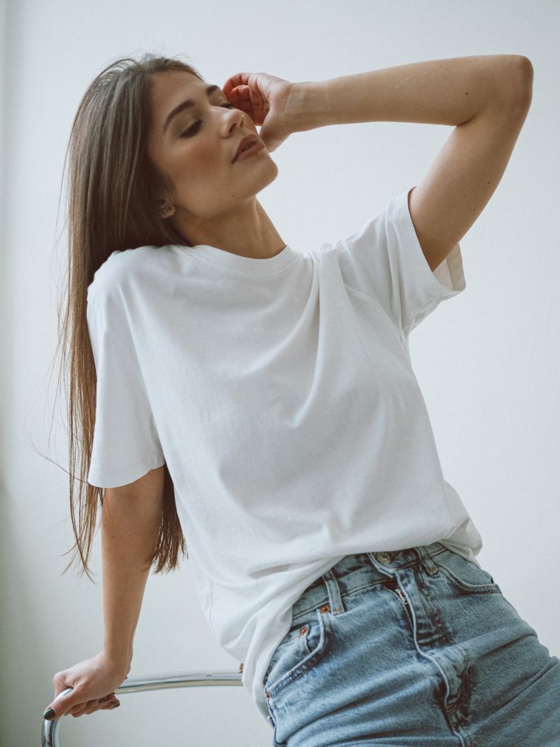 Woman in a white tee with thrifted straight-leg jeans