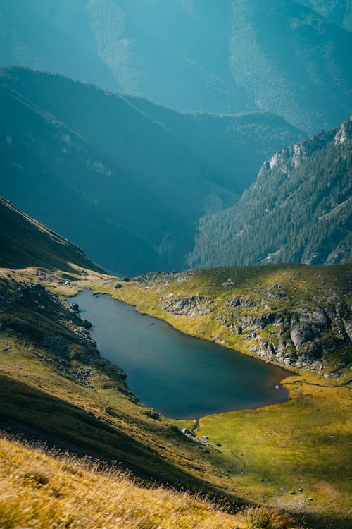 Free A Lake in the Middle of Green Mountains Stock Photo