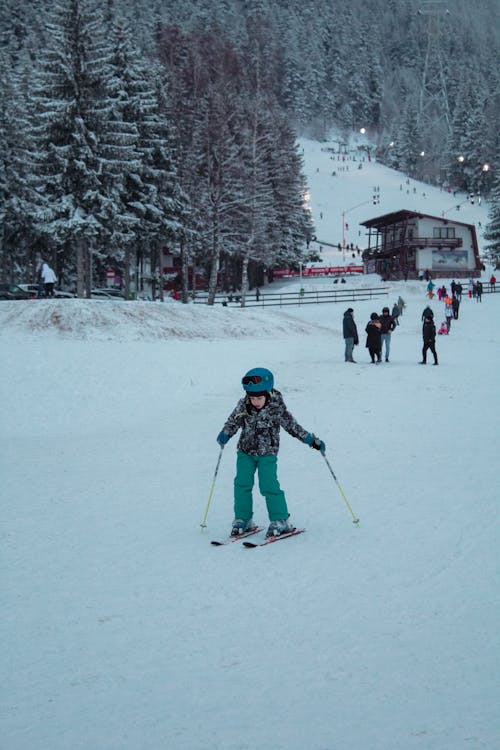 A Young Kid Skiing on a Snow Covered Ground