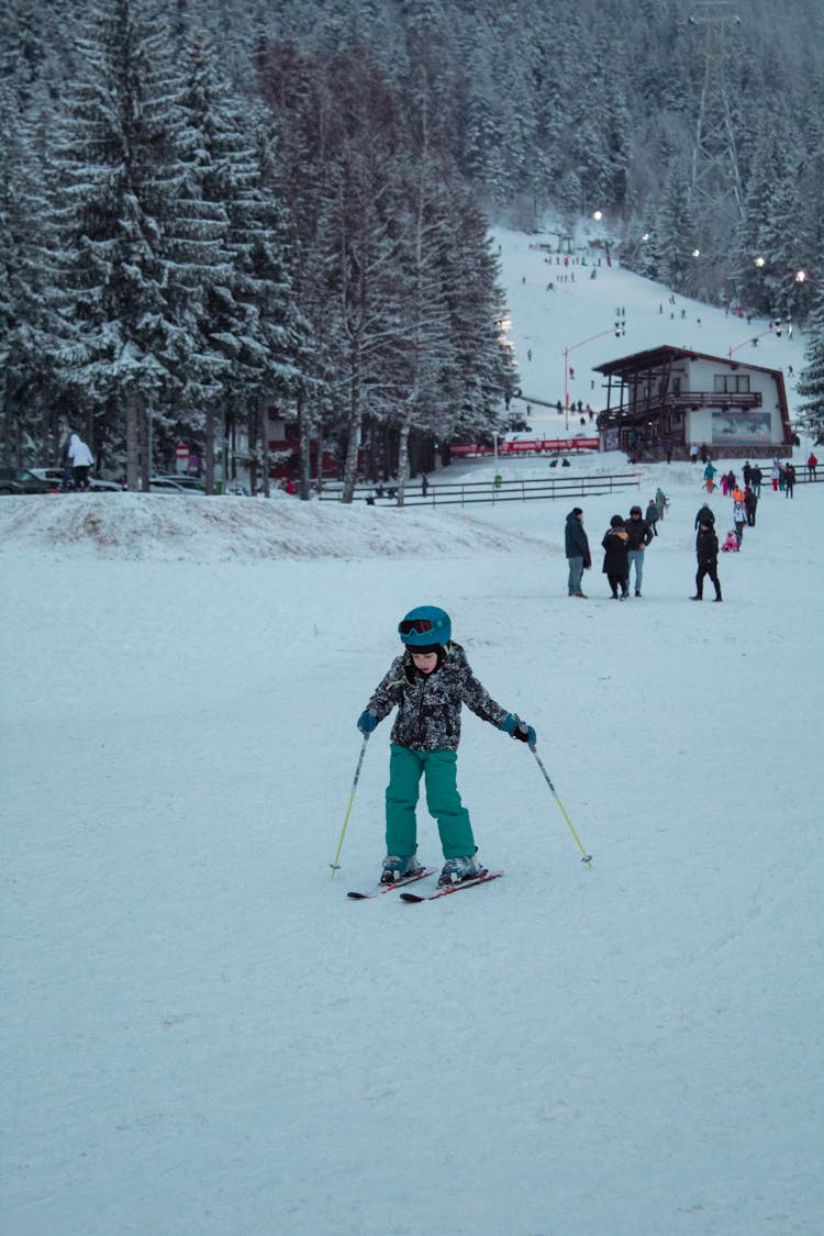 A Young Kid Skiing On A Snow Covered Ground