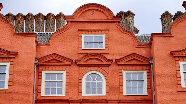 Front view of a vibrant orange brick building facade with classic windows.