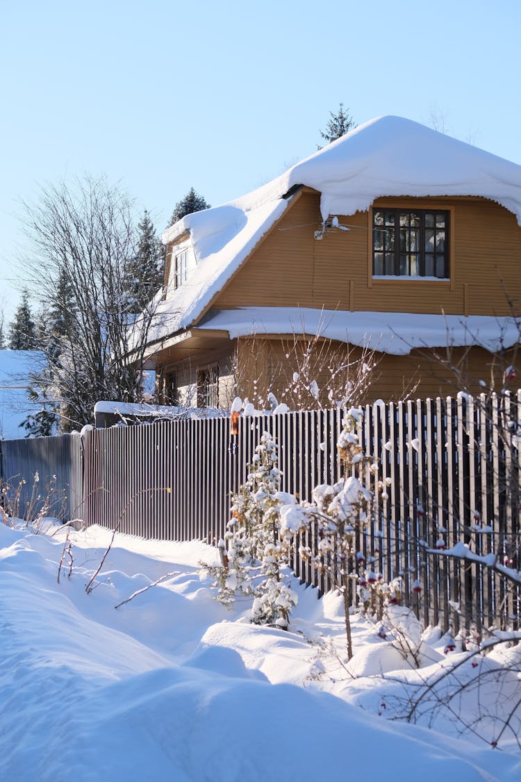 A Wooden House Covered In Snow