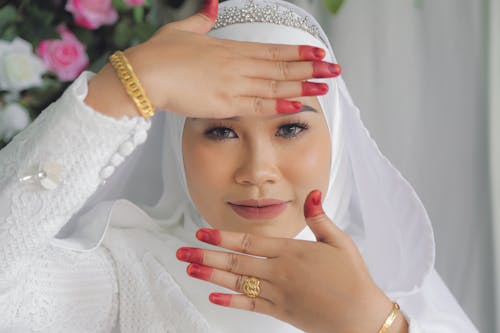 A Woman in White Hijab Showing Her Hands with Red Dye