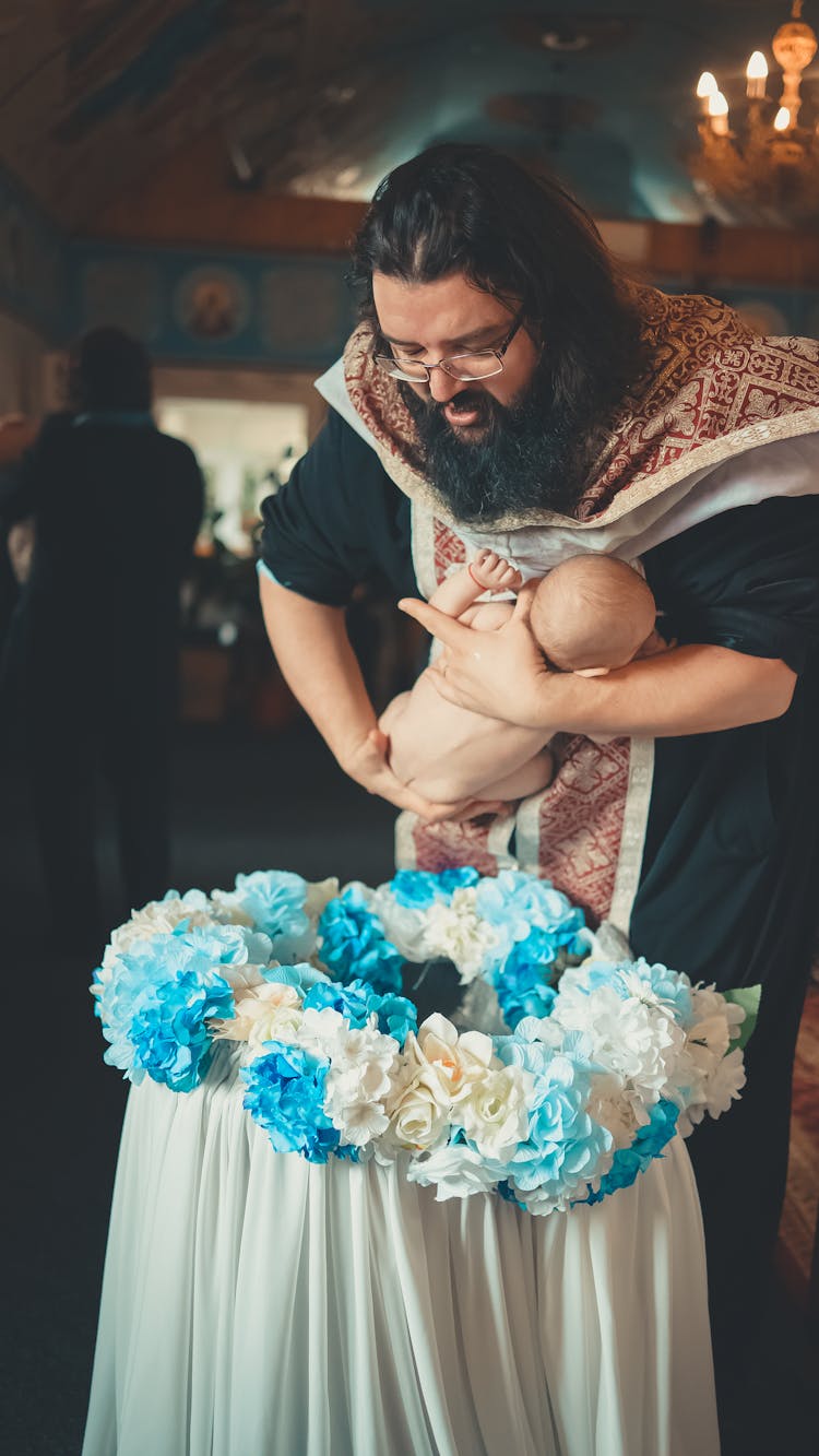 Priest Christening Baby In Church