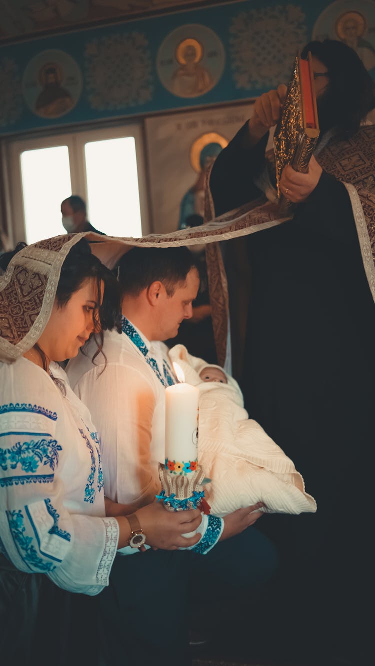 Couple Christening Baby In Church