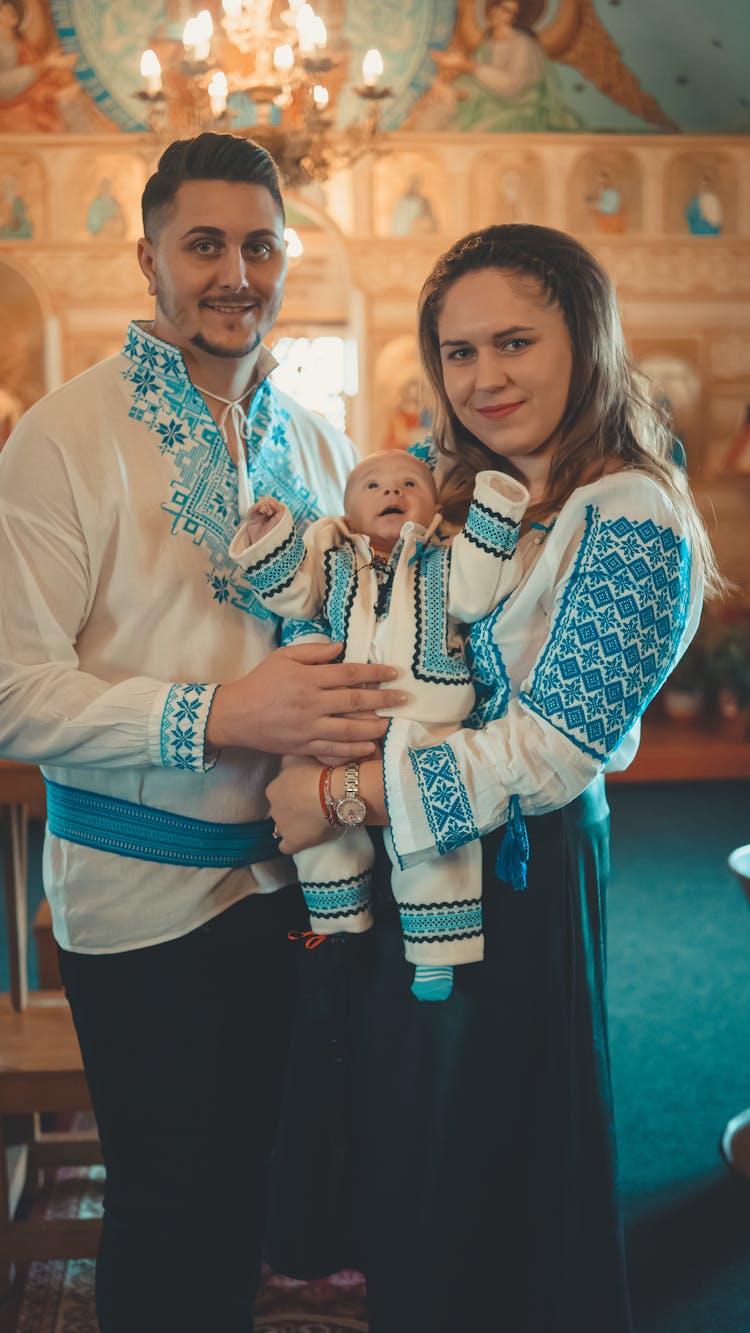 A Couple Carrying Their Newborn Baby