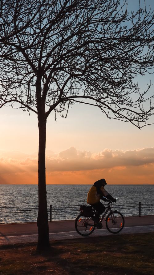 Free Person cycling along the coast of İstanbul with a beautiful sunset backdrop. Stock Photo