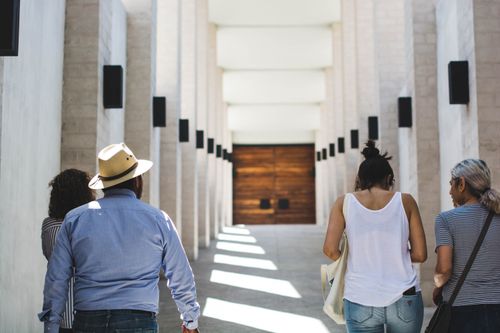 Free People strolling in a sunlit architectural corridor, showcasing modern Mexican design. Stock Photo